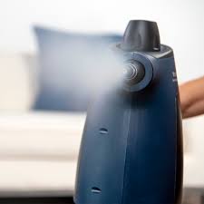 Blue humidifier emitting mist in a living room setting