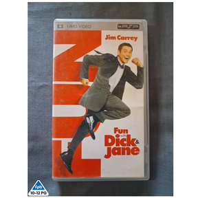 A PSP video game case for 'Fun Dick & Jane' starring Jim Carrey, resting on a dark gray fabric surface. The cover features a large orange and white graphic background with an illustration of Jim Carrey in a suit.