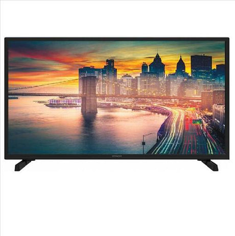 A black flat-screen television displaying a vibrant city skyline and bridge scene at sunset, shown against a plain white background.