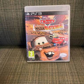 Disney Pixar Cars Mater National PS3 video game in a clear plastic case, resting on a textured brown fabric surface.