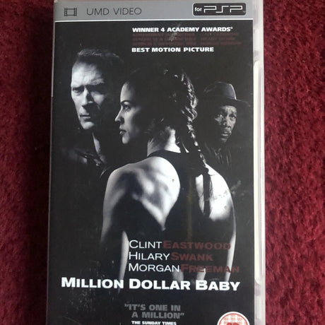 A VHS case for the movie 'Million Dollar Baby' with Clint Eastwood, Hilary Swank, and Morgan Freeman, photographed on a textured red fabric background.