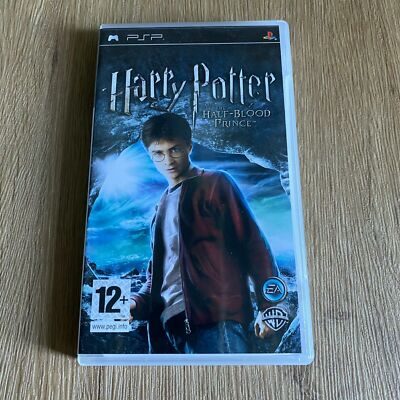 A PSP game case for Harry Potter and the Half-Blood Prince, featuring artwork of Harry wearing his red robe against a blue magical background, photographed on a light wood surface.