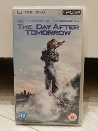 A PSP UMD video case for the movie 'The Day After Tomorrow' sitting on a light-colored wooden surface. The cover art features a dramatic illustration of the Statue of Liberty rising from turbulent water under a pale sky.
